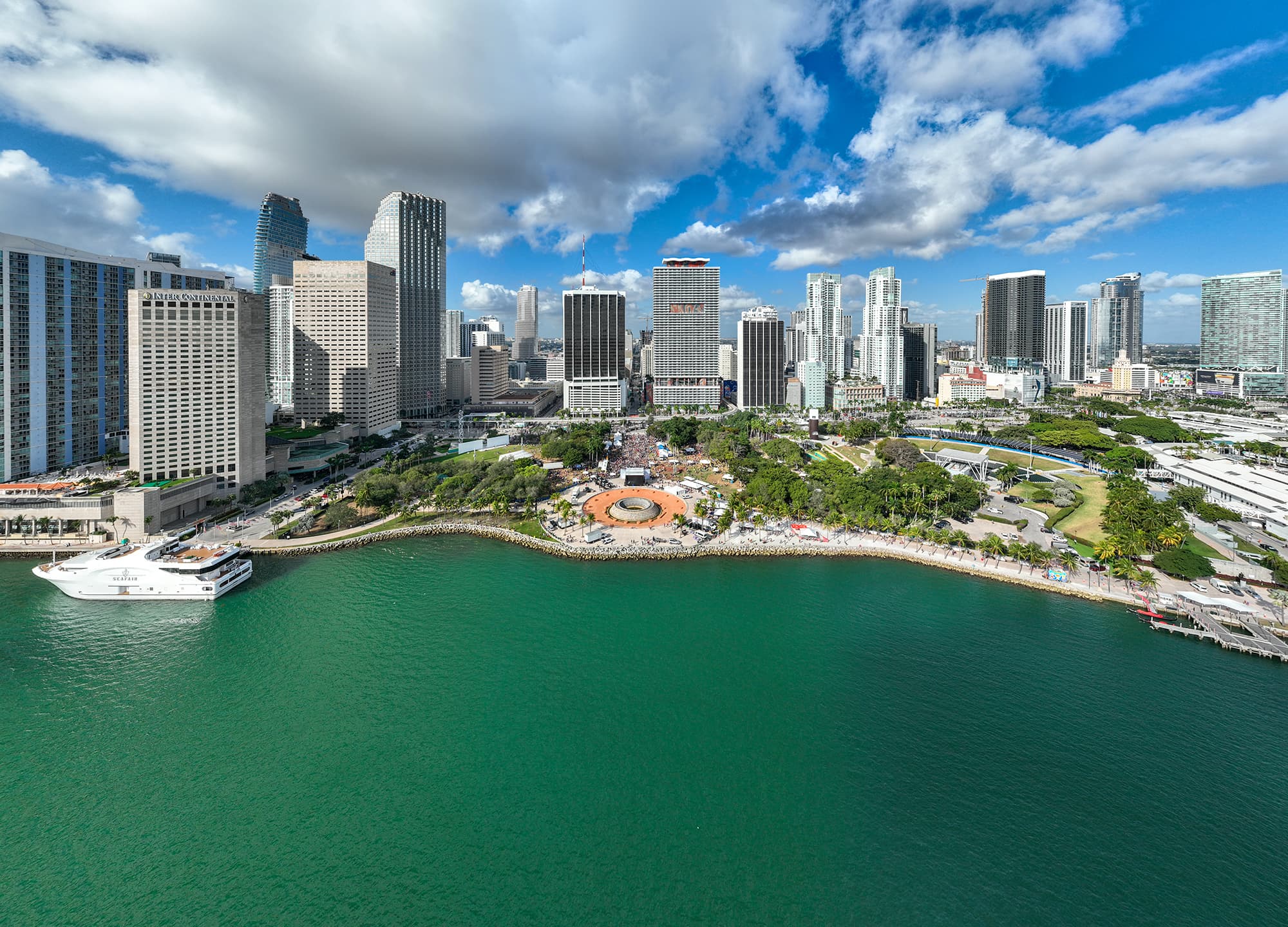 Aerial view of a waterfront city skyline with high-rise towers and open water in the foreground